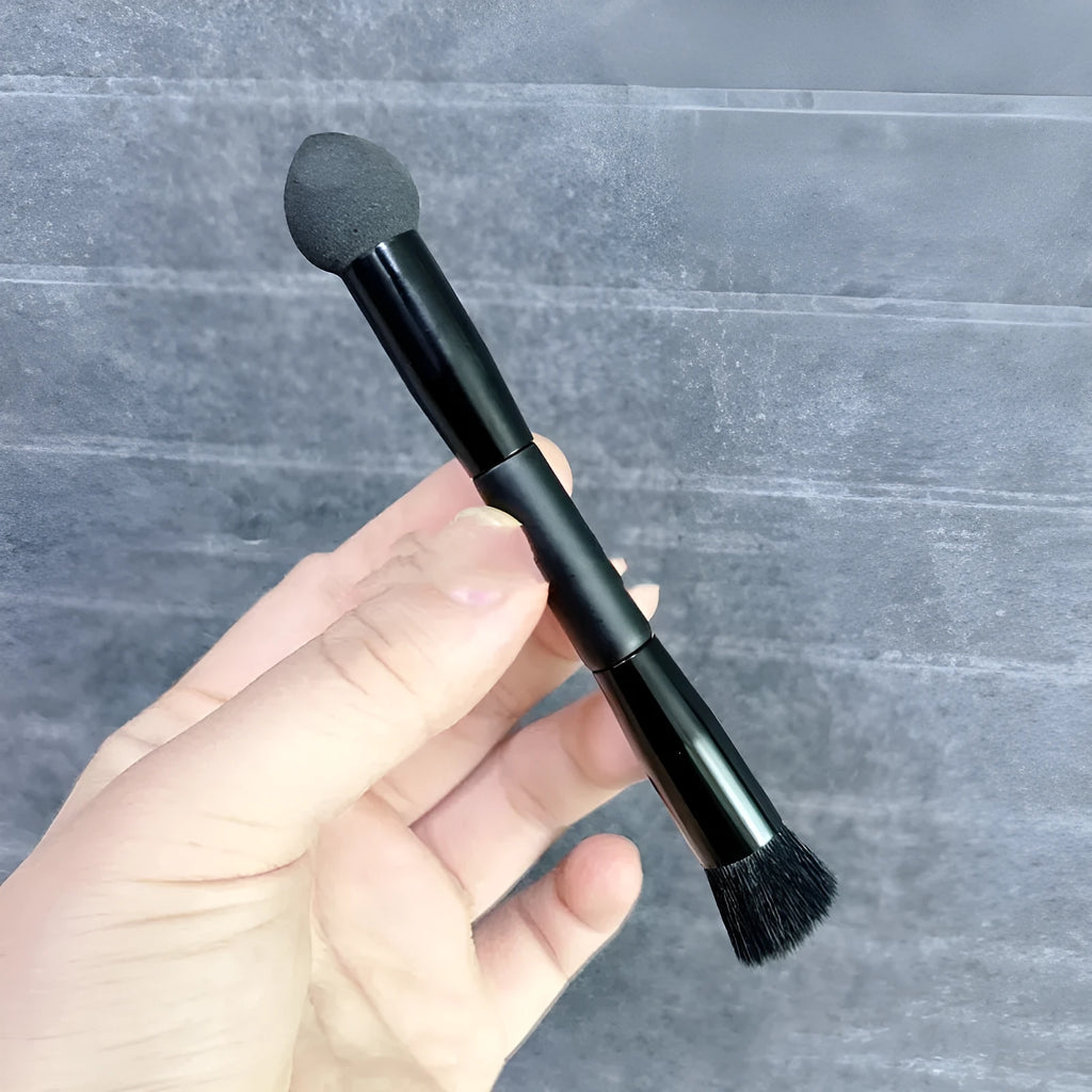 Black sponge stick concealer brush with wooden handle on white background