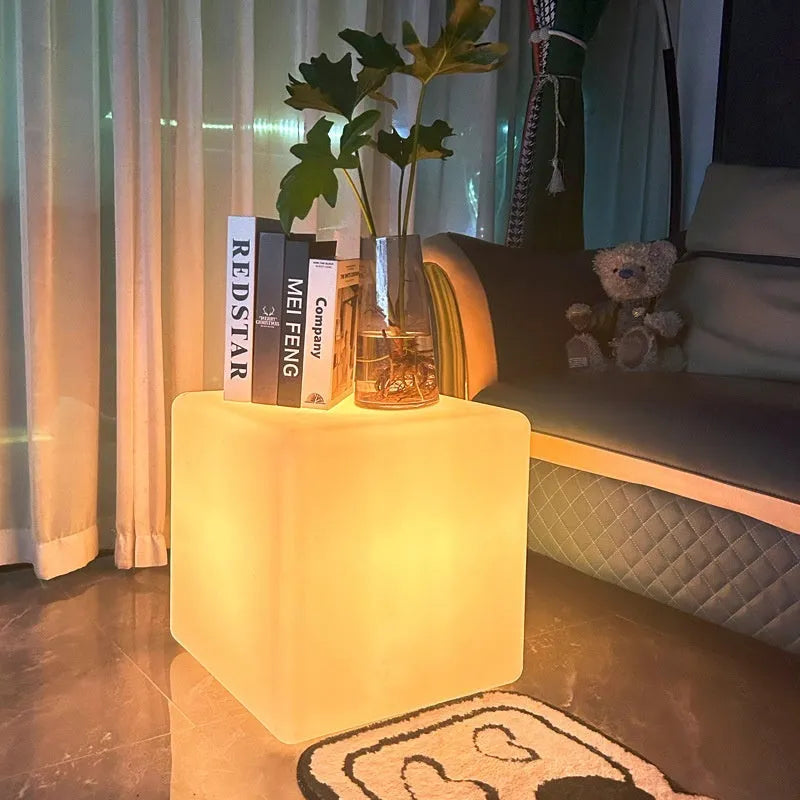 Modern square white LED cube light stool outdoors on a patio.