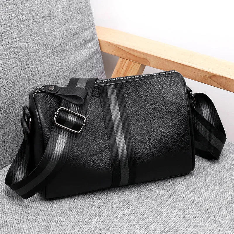 Black genuine leather crossbody bag showing front view with single shoulder strap