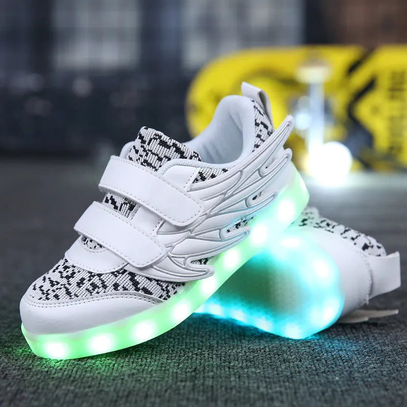 Children's plum red and white sneakers with colourful LED lights glowing on the side.