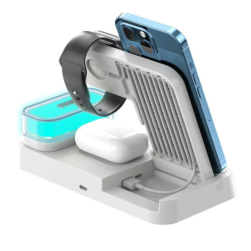 4-in-1 wireless charger station with alarm clock display and foldable stand charging a phone, headphones and watch