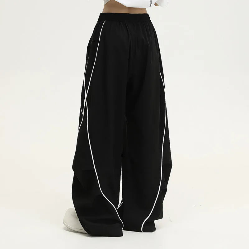 Black pleated wide-leg trousers with striped pattern showing mid-waist design and loose fit