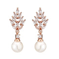 Geometric flower shaped earrings with micro inlaid zircon stones and pearl details on gold plating.