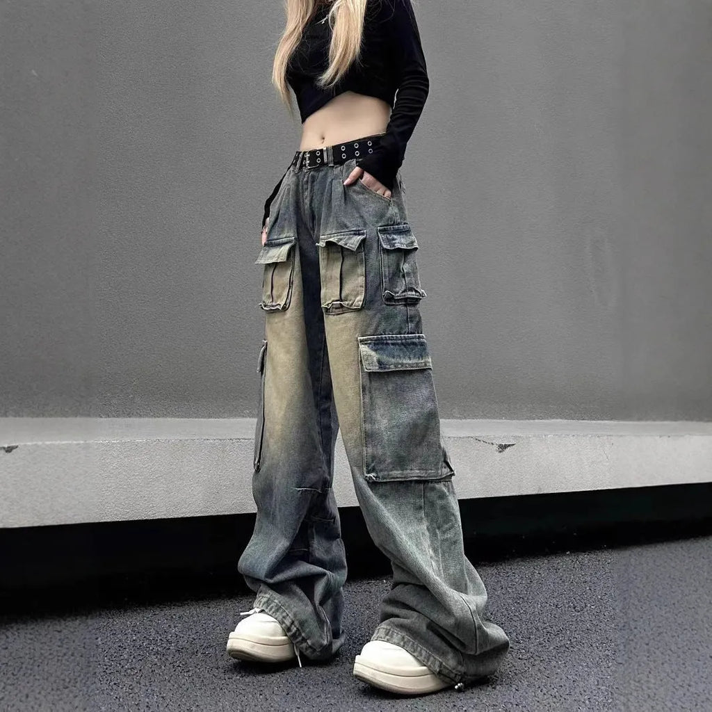 Man wearing loose fit light blue distressed jeans with multiple tooling pockets and straight leg silhouette.