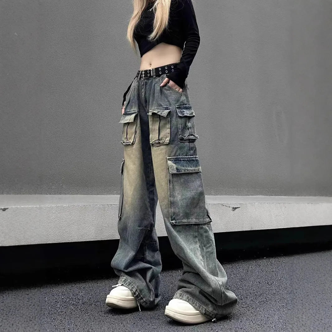 Man wearing loose fit light blue distressed jeans with multiple tooling pockets and straight leg silhouette.
