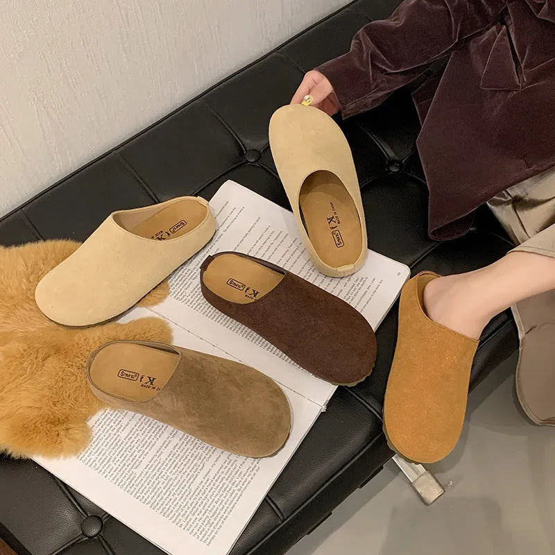 Flat apricot coloured slip-on slippers with a square toe and microfiber upper on a light surface.