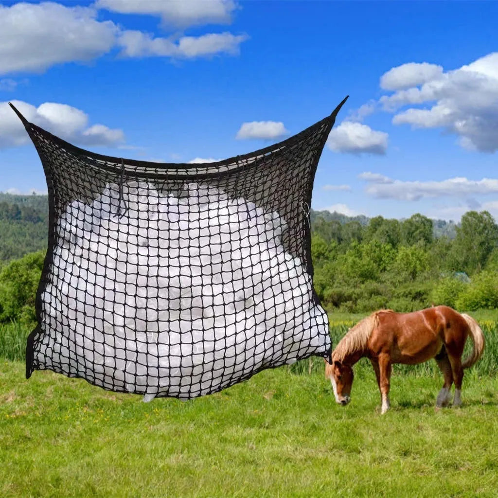 Woven PE rope horse feeding bag with grid pattern in black colour, shown hanging with hay