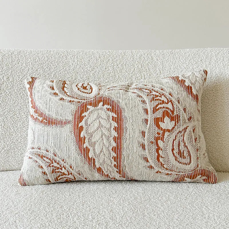 American-style amber jacquard pillow cover with paisley plant pattern, shown on a sofa.