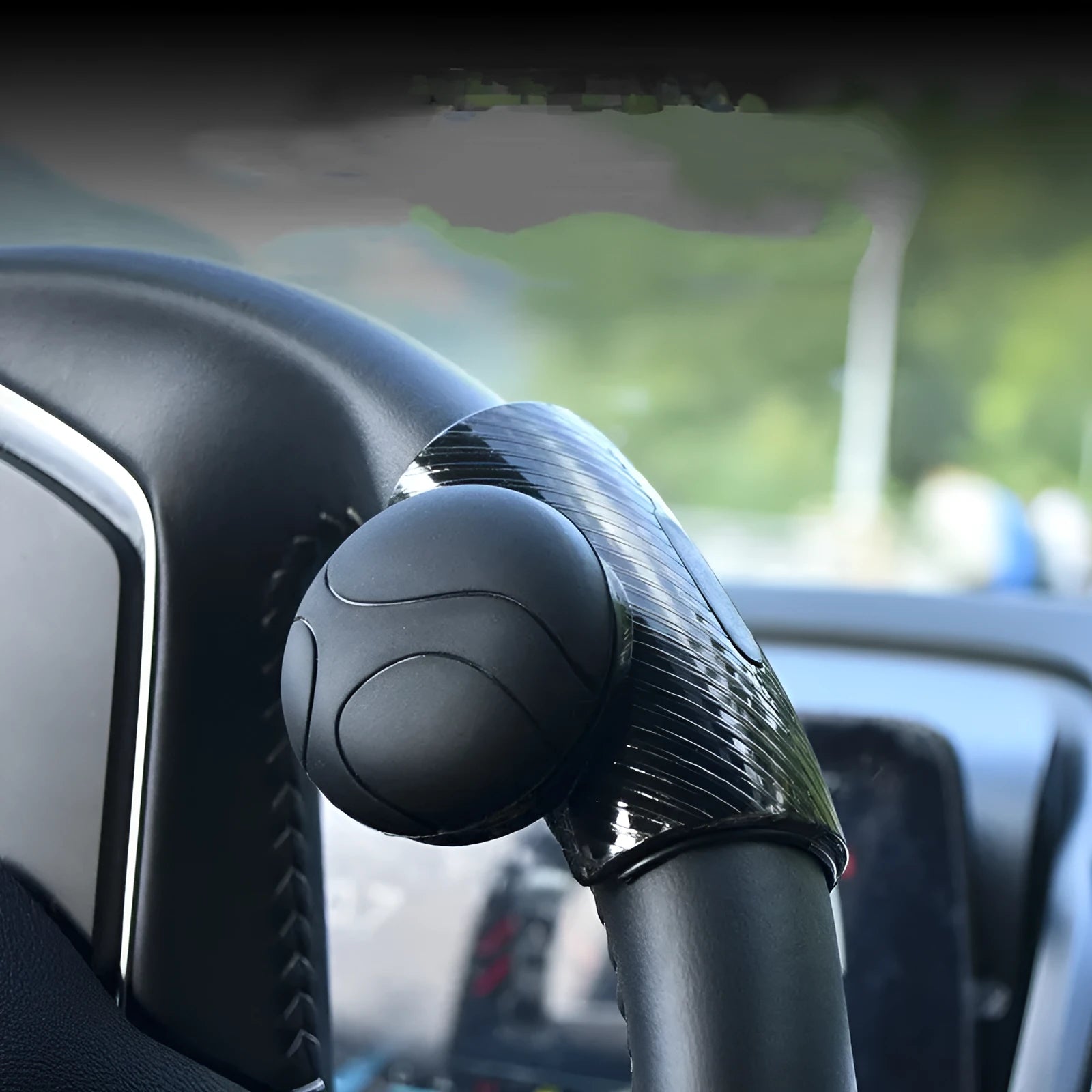 Black and blue steering wheel assist ball with silicone grip and metal bearing for single-handed steering.