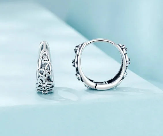 Pair of sterling silver hollow butterfly earrings with zircon accents, showing retro design.
