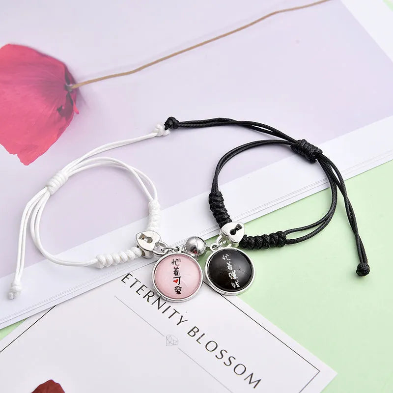 A pair of silver alloy bracelets with magnetic clasps and assorted charm designs including crowns, stars, and clovers.