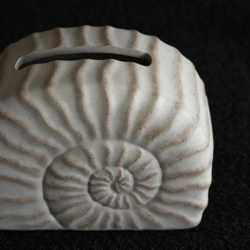 Modern conch ramble patterned resin decorative tissue box holder on a table.