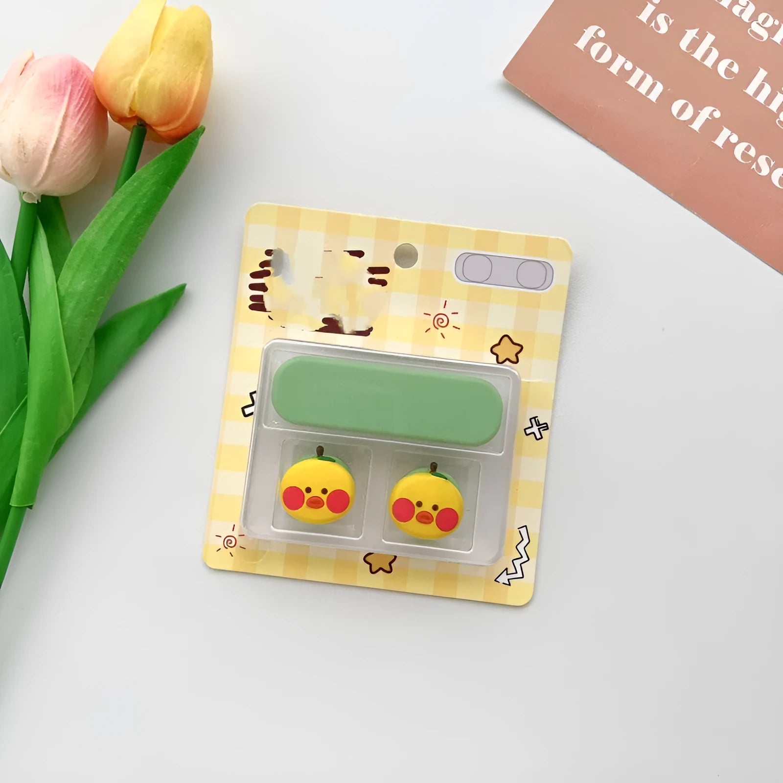 Colourful cartoon character plastic clip holding a magnetic charging cable on a desktop