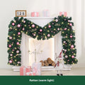 Pink Christmas rattan vine garland draped in a loop, showing small fruit details and LED lights.