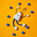 Blue plush cat toy with mint bell and elastic rope on floor