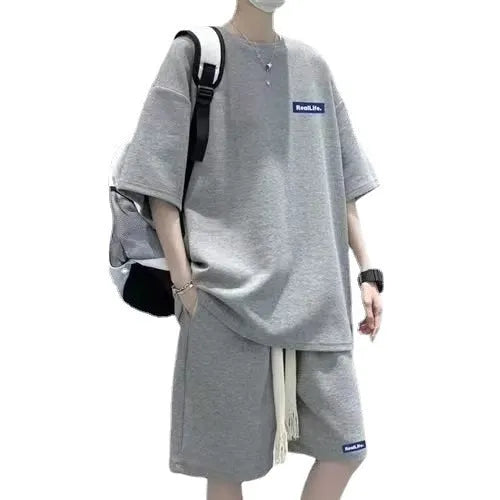 Man wearing a waffle-textured grey cotton short sleeve top and matching shorts from the leisure sport suit set.