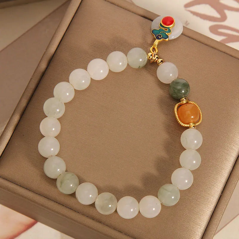 Women's Ice Jade jade bracelet with a Xiangyun peace buckle and pearl details on a white background.