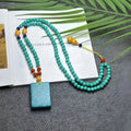 Turquoise stone pendant necklace with hand-woven mesh flower design on adjustable ball bead chain