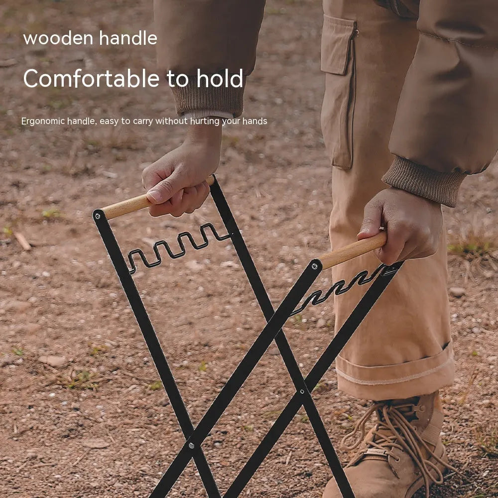 Black folding iron trash rack with a wooden handle holding a rubbish bag outdoors.