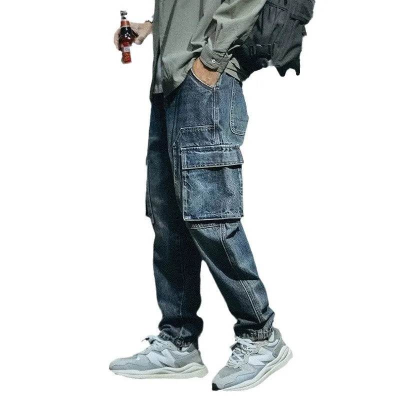 Blue men's loose straight leg stretch trousers with zip fly on a neutral background.