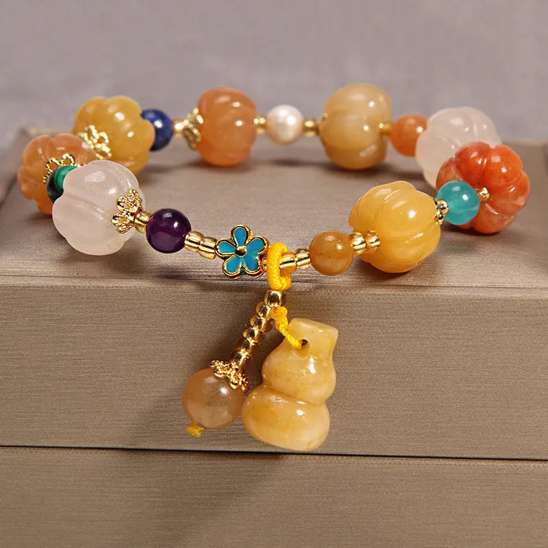 Close-up of a khaki yellow agate crystal bracelet with gold silk threading on a wrist.