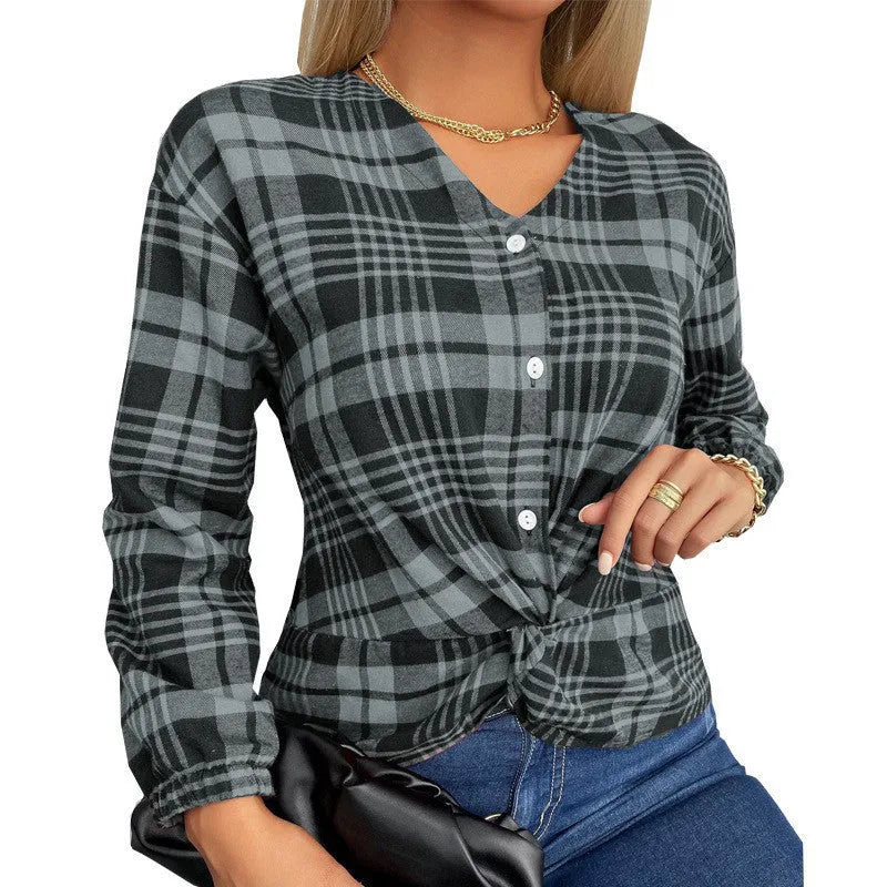 Woman wearing a loose-fitting purple plaid shirt with regular sleeves.