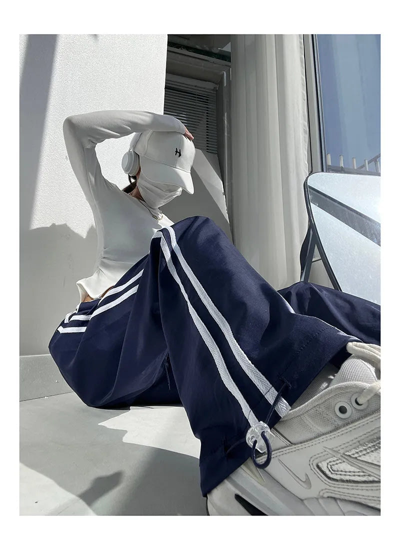 Navy blue loose straight-leg trousers with contrast detail, shown on a hanger.