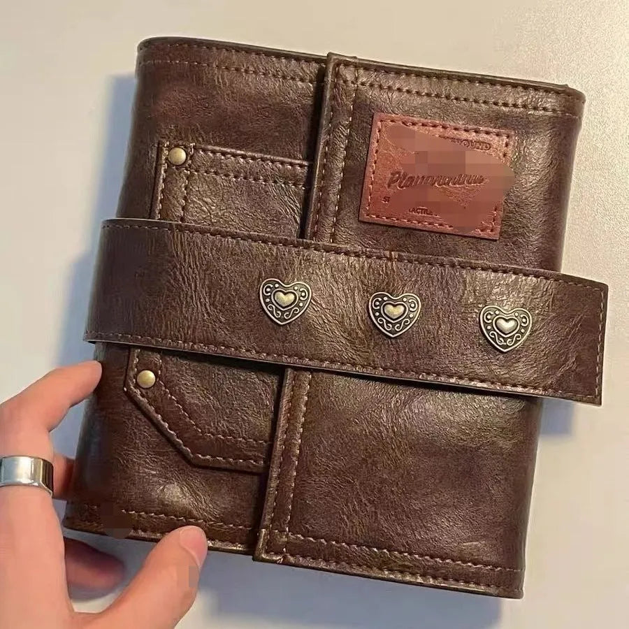 Brown A7 notebook with leather-style buckle closure showing loose-leaf binding