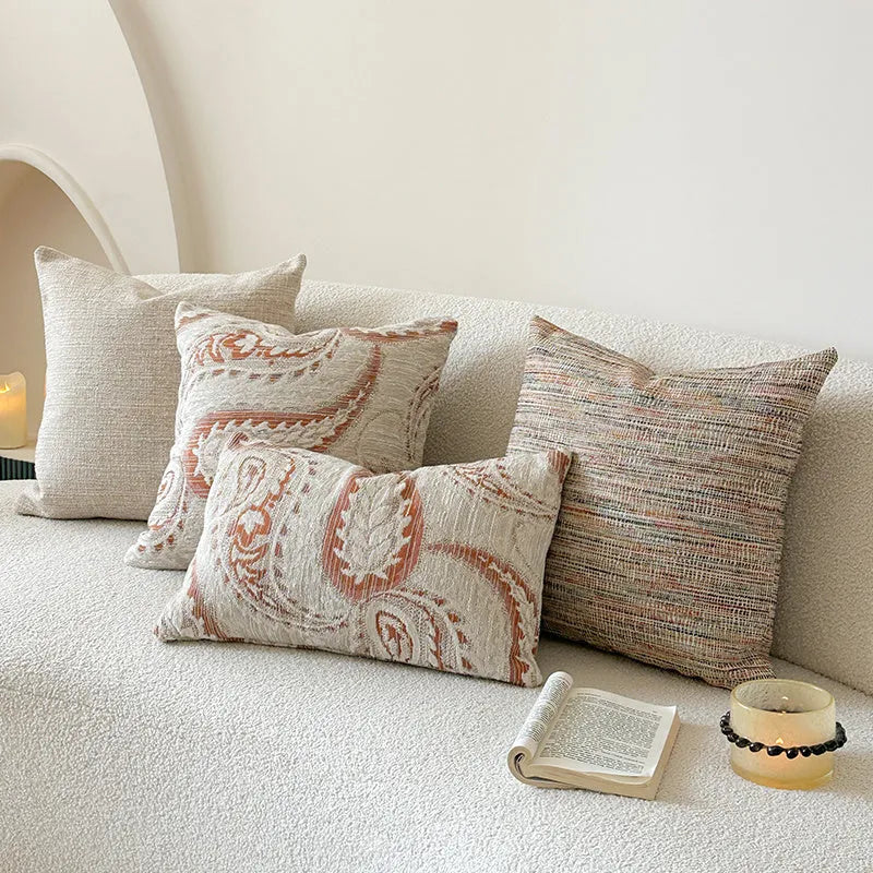 American-style amber jacquard pillow cover with paisley plant pattern, shown on a sofa.
