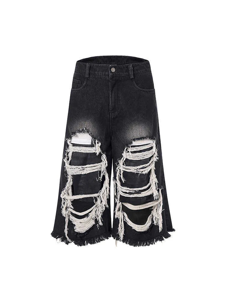 Black cropped wide-leg women's jeans with ripped patch detail on the knee.