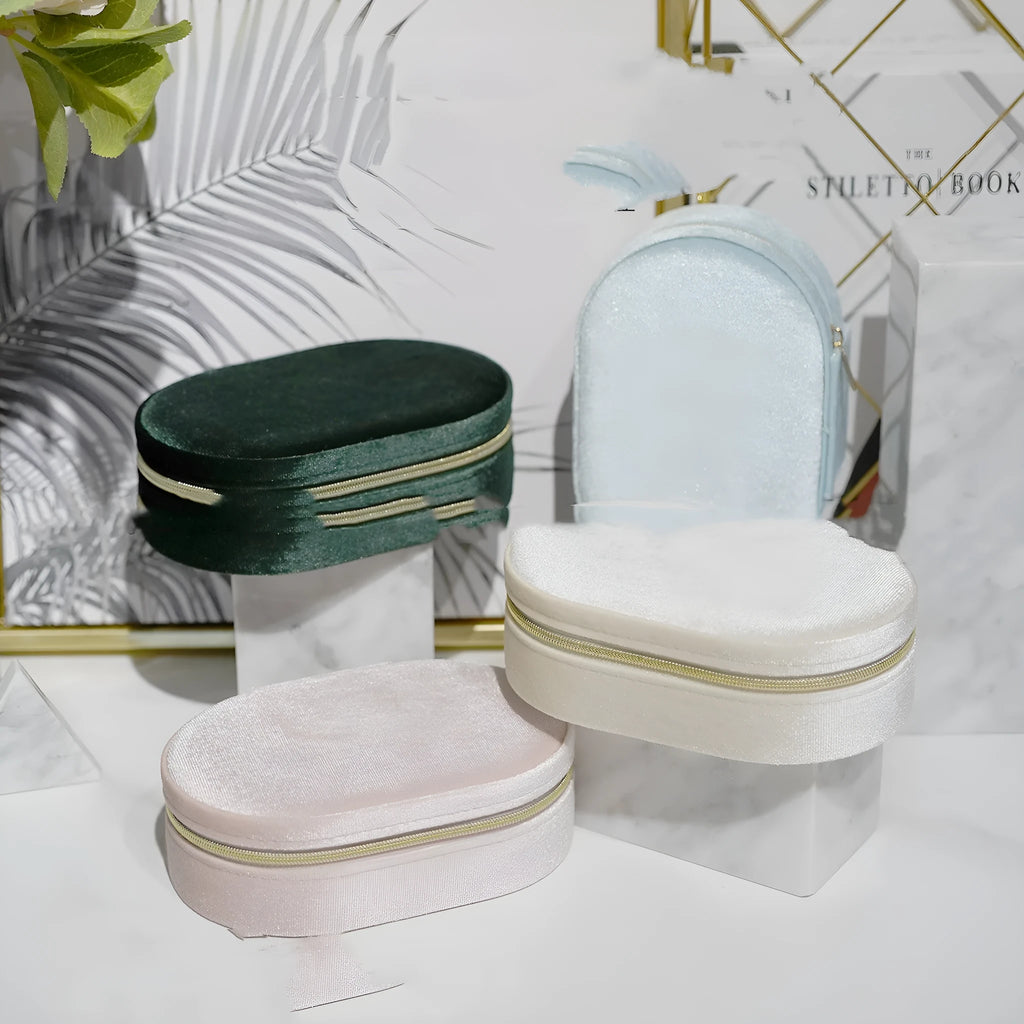 Oval velvet jewellery box in lake blue colour with flannel interior, shown with rings inside.