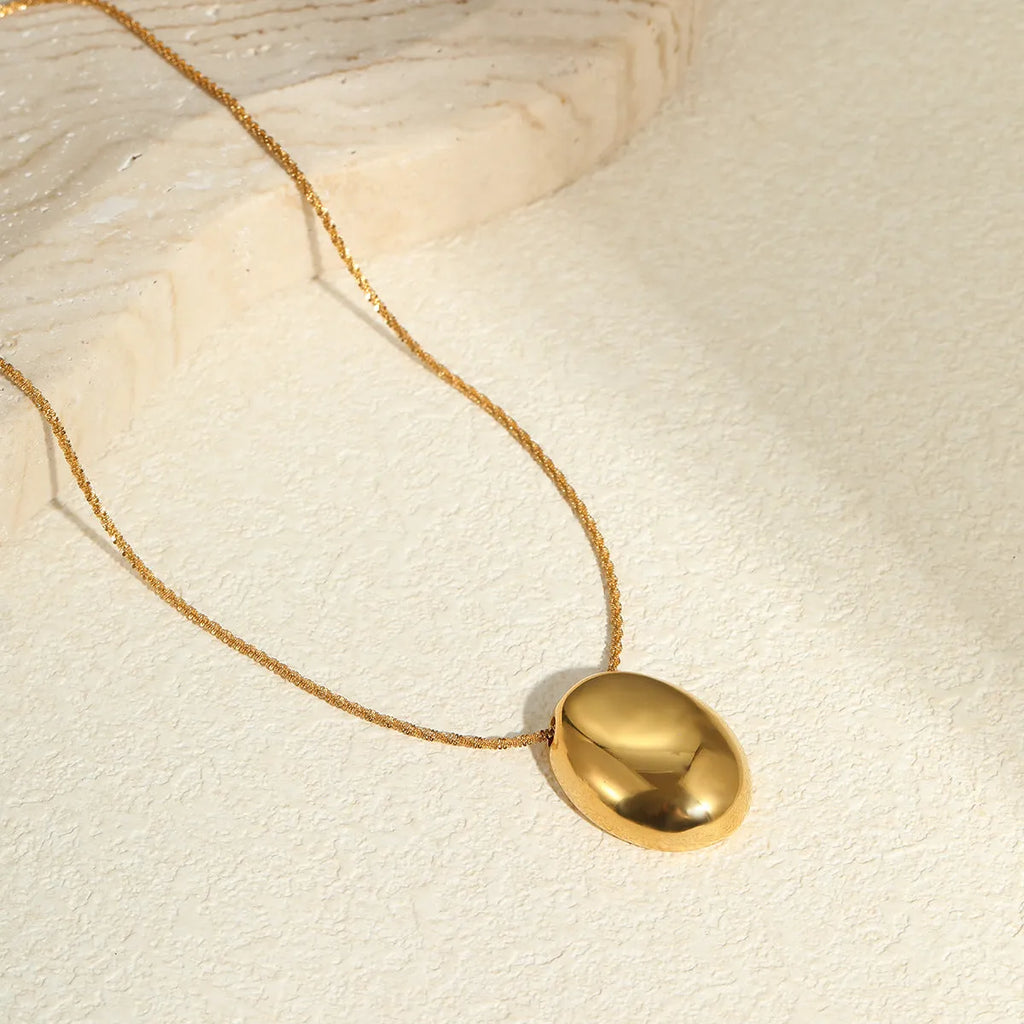 Gold geometric pendant on an adjustable stainless steel necklace chain.