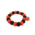 Orange Halloween pumpkin dog cat collar with green ribbon leaf, black stripes, jingle bell, and breakaway buckle on grey background.