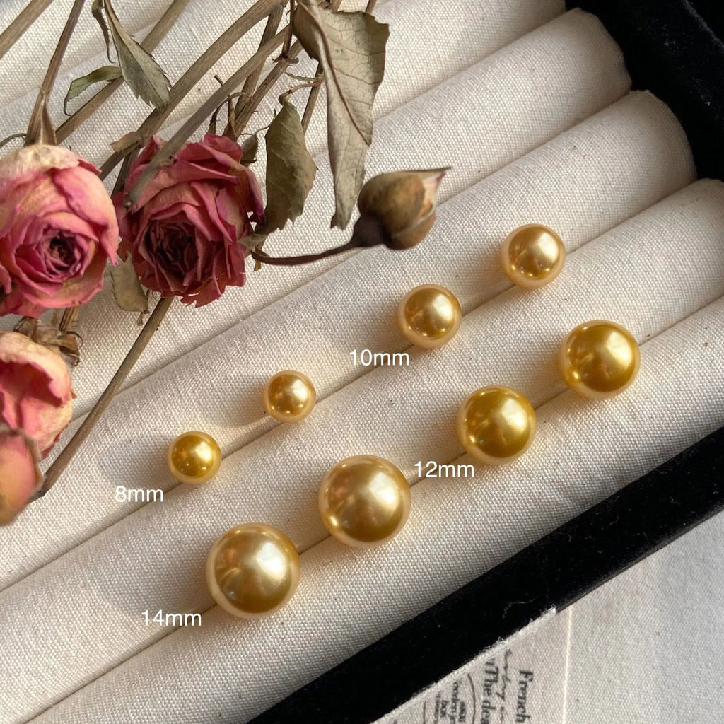 A pair of large geometric pearl stud earrings with an eight-point star accent on a silver setting.