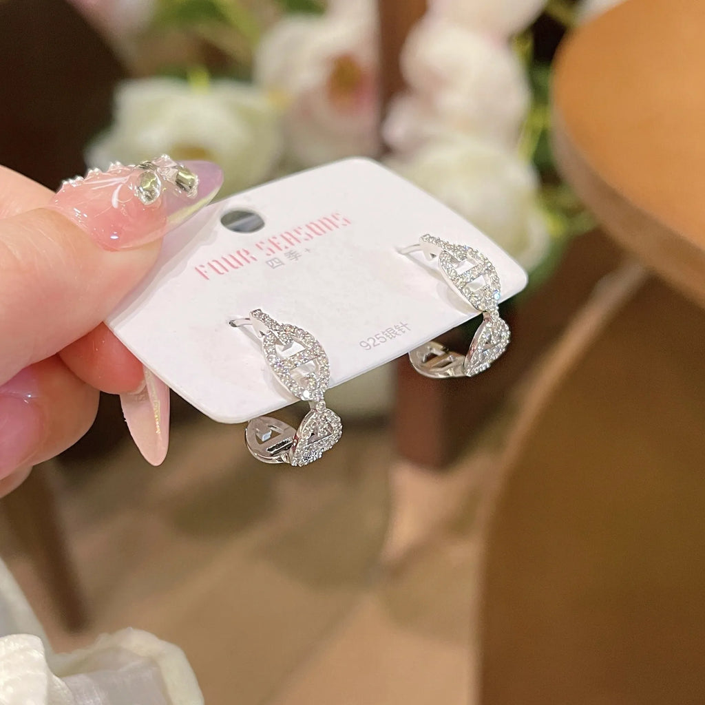 A pair of women's diamond-look fashion earrings with thick gold plating, shown in silver, gold, and rose gold colour options.