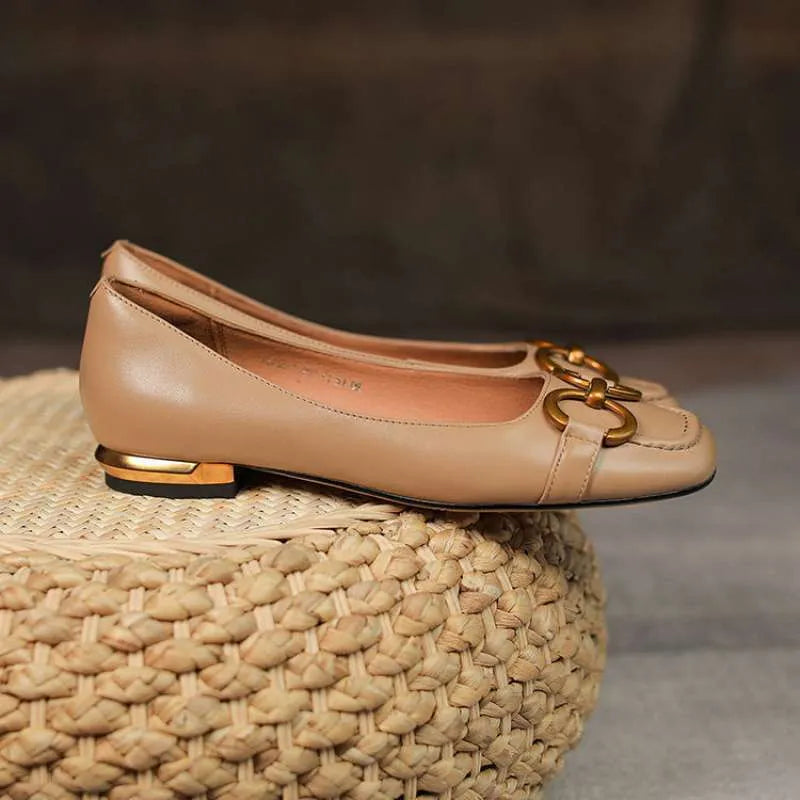 Women's black square toe Mary Jane pumps with metal detail and a low heel on a rubber sole.