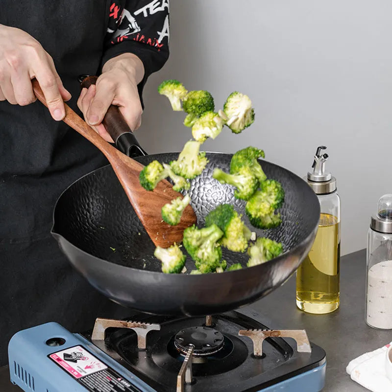 Traditional handmade iron wok pan with wooden handle and black finish