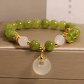 Natural stone green tourmaline women's bracelet with peace buckle and lucky bag charm on display