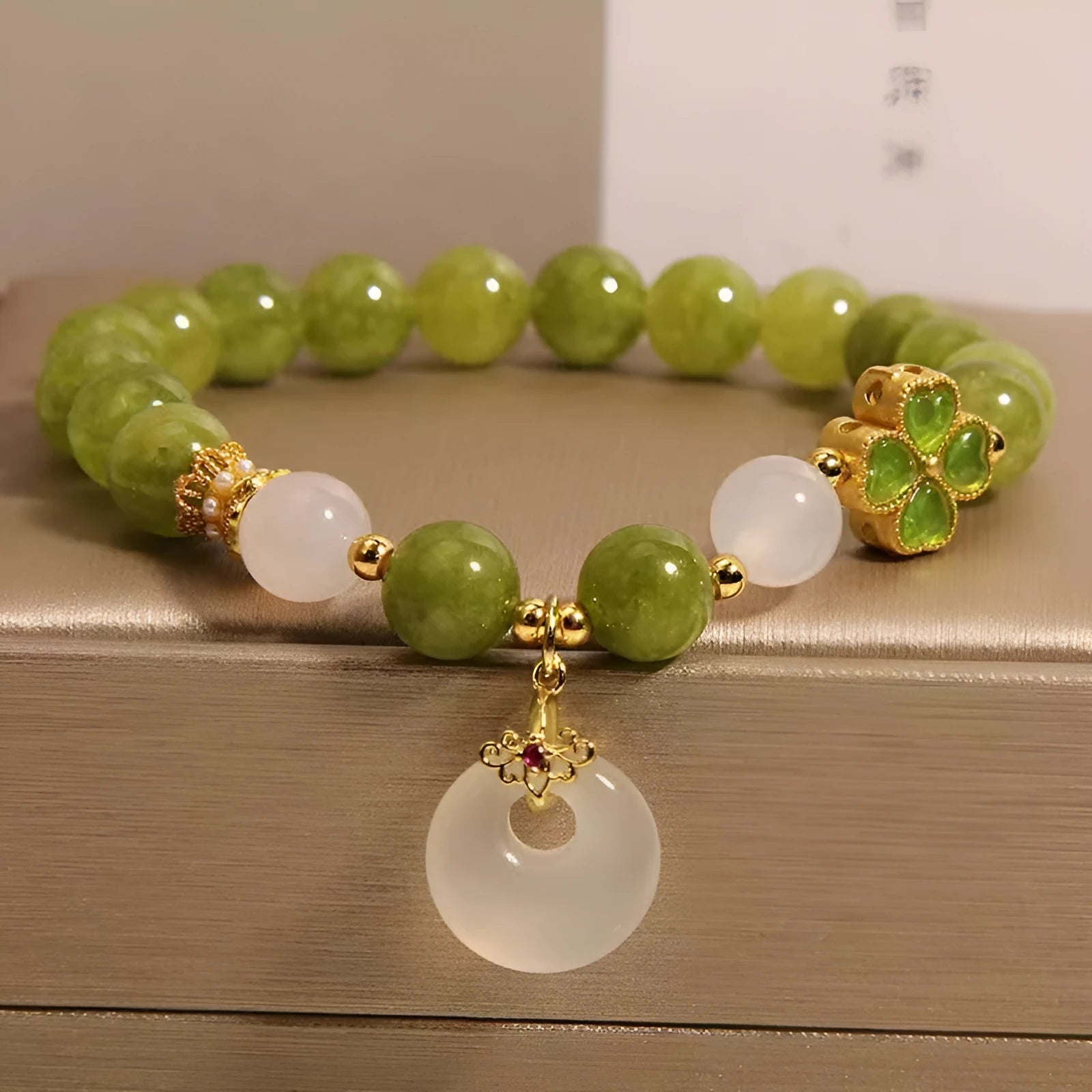 Natural stone green tourmaline women's bracelet with peace buckle and lucky bag charm on display