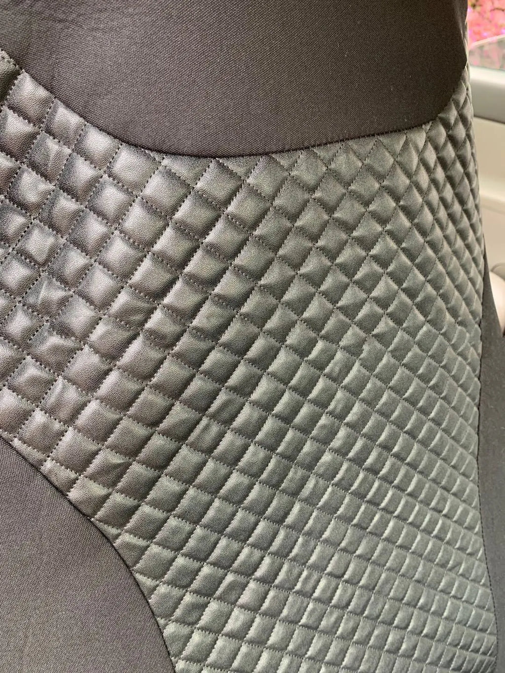 Black quilted automotive seat cover made from PU and polyester fabric with plastic attachment hooks