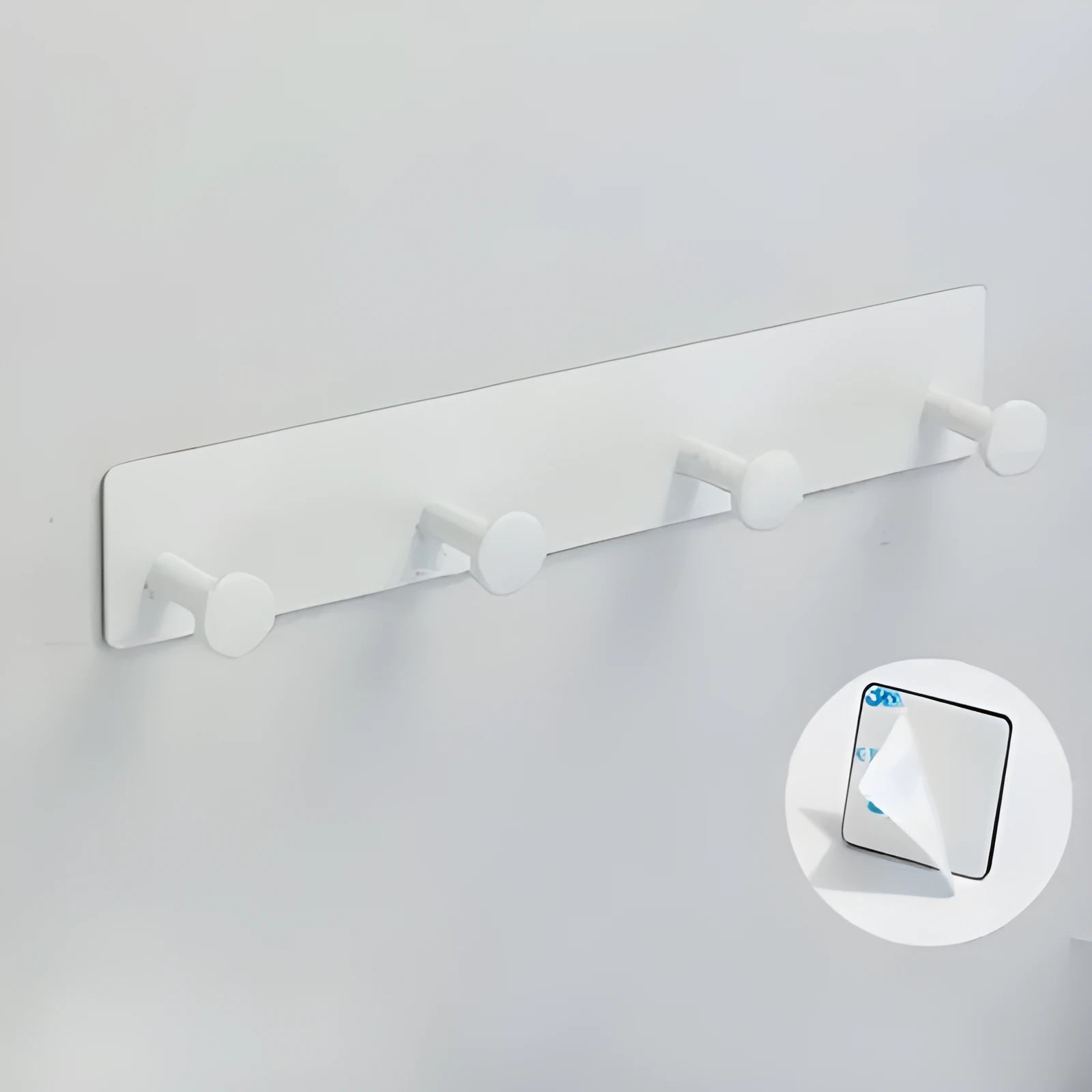 Iron screwless wall hook with multiple hooks mounted with adhesive tape on a glass shower door.