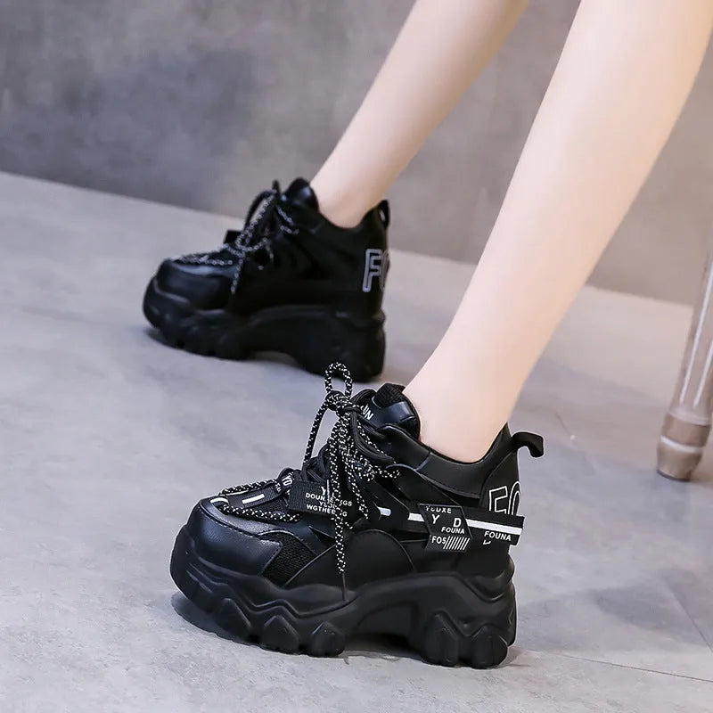 White and black women's low-top platform sports shoes with cross-strap and mesh design on a rubber sole.