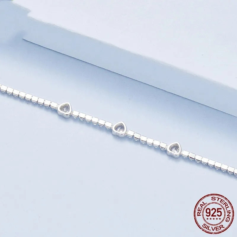 S925 sterling silver bracelet with heart-shaped clear zircon centrepiece on light background