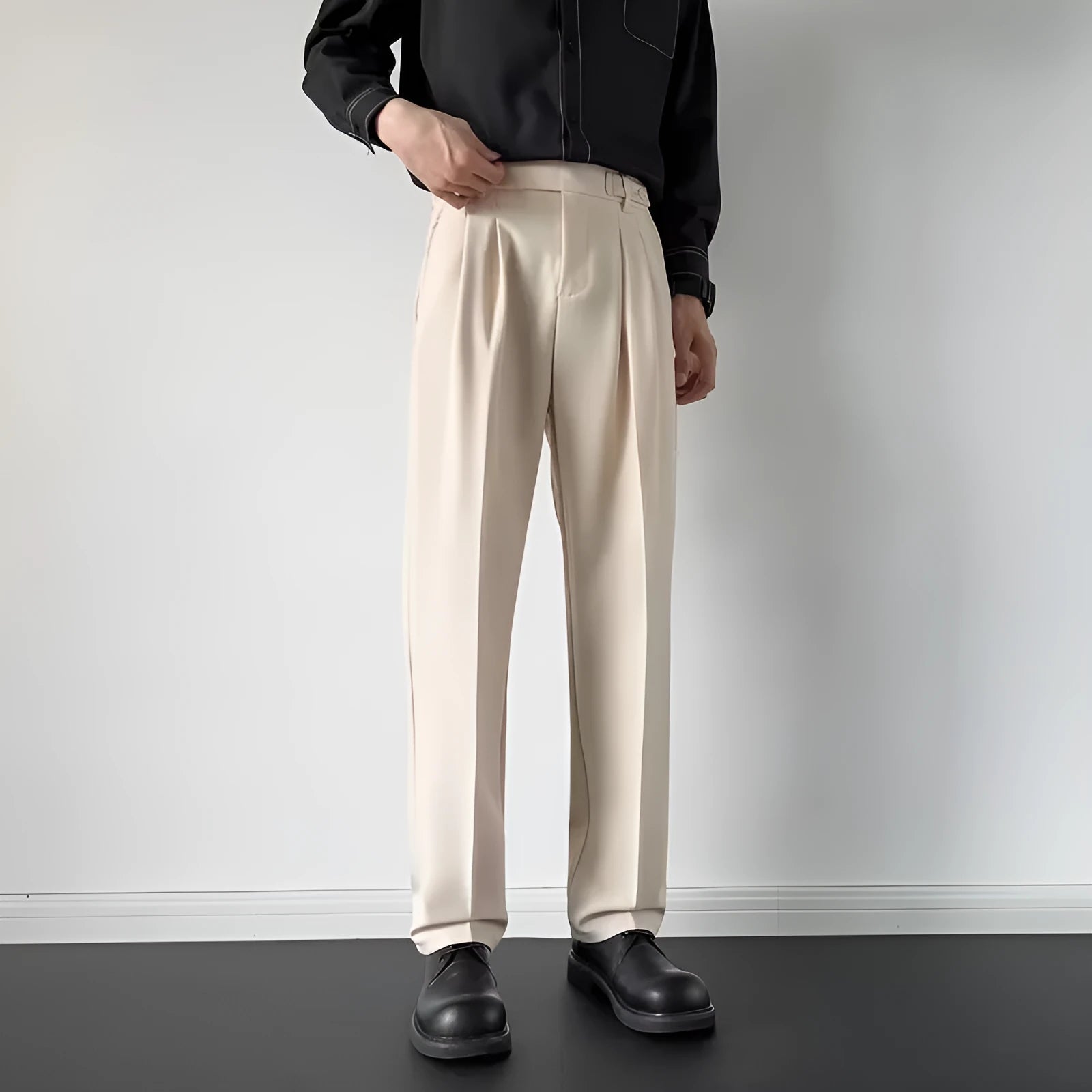 Men's apricot and black straight-leg suit trousers with a loose fit on a hanger.