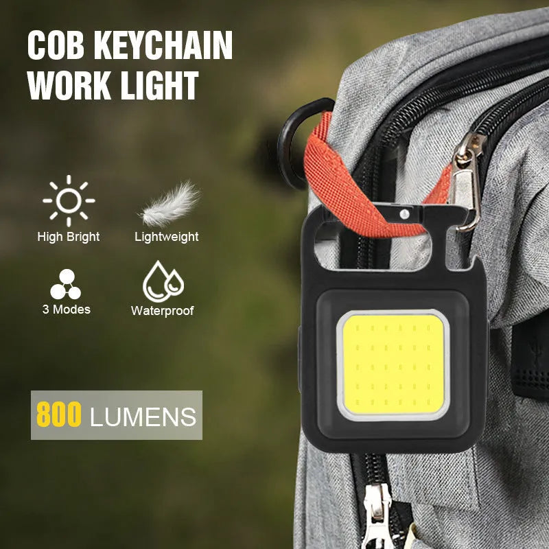 Black aluminium alloy keychain light with COB LED, magnetic base, and foldable handle on keyring