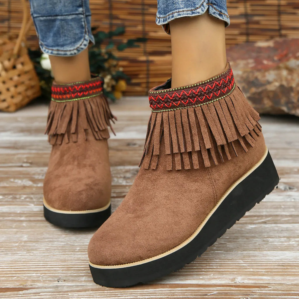 Women's dark brown suede ankle booties with a wedge heel, side zipper, and tassel detail