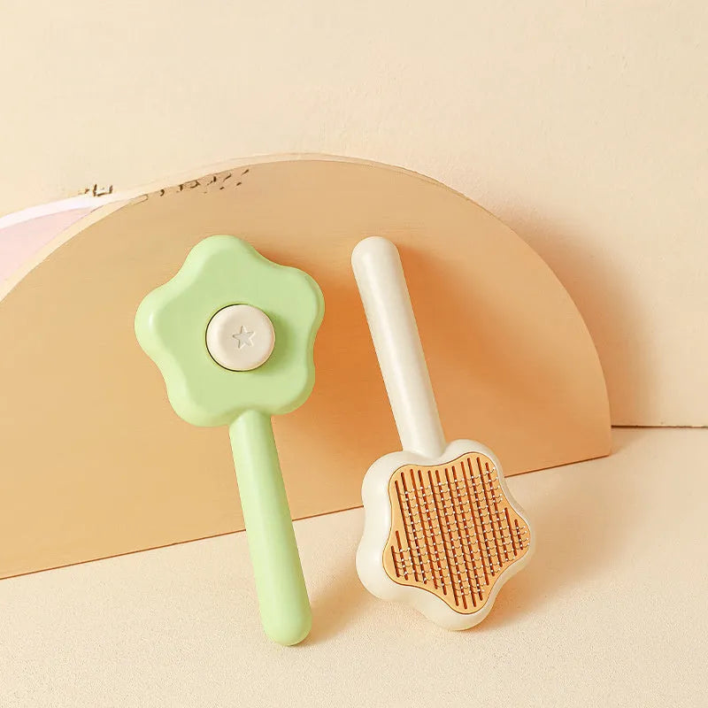 Green cat comb with stainless steel needles and self-cleaning magic wand function on white background