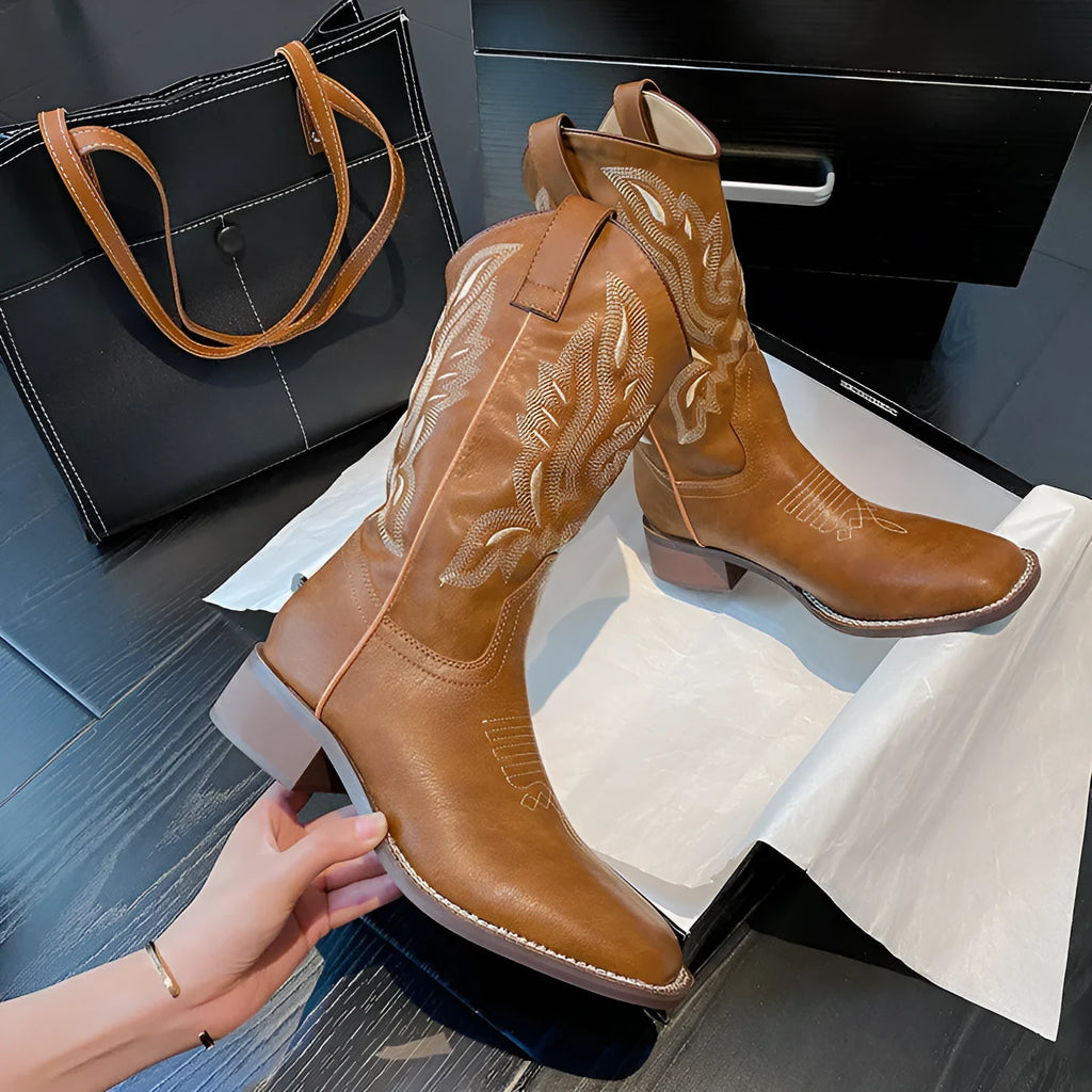 Brown women's mid-calf boots with embroidery detail on the shaft, shown from the side.