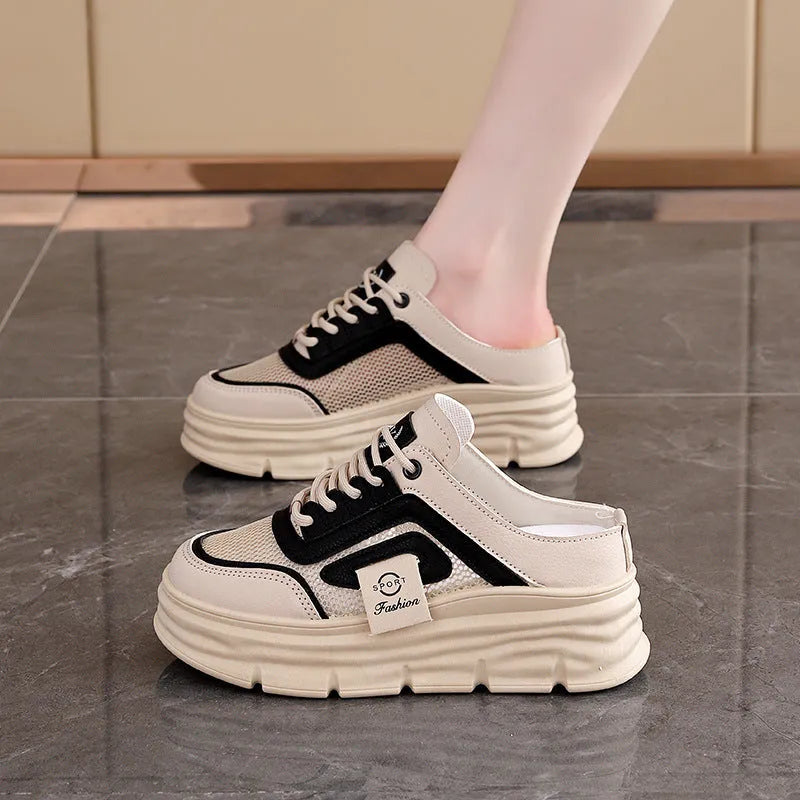 Women's black mesh half slipper with a round toe and rubber sole, shown from the side.