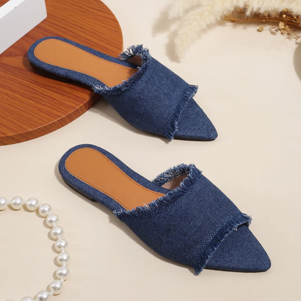 Women's denim flat slippers with tassel detail in apricot colour on a white background.
